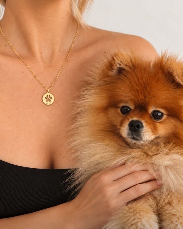Kucağında Pomeranian köpeğiyle, boynunda BIADORA kolye ucu taşıyan kadın